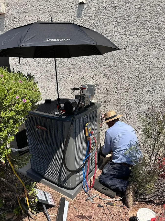 HVAC technician performing outdoor AC maintenance in Town of Pecos